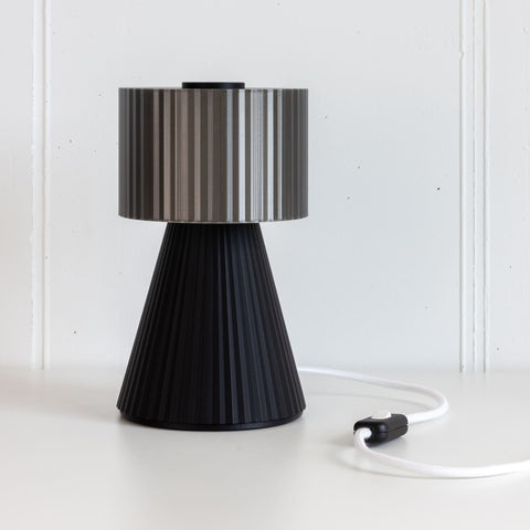 Lustra Plissé table lamp in Smoke Black on white background with cable